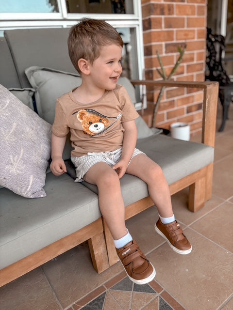 A happy toddler wearing Billycart Kids Archie soft sole Tan sneakers