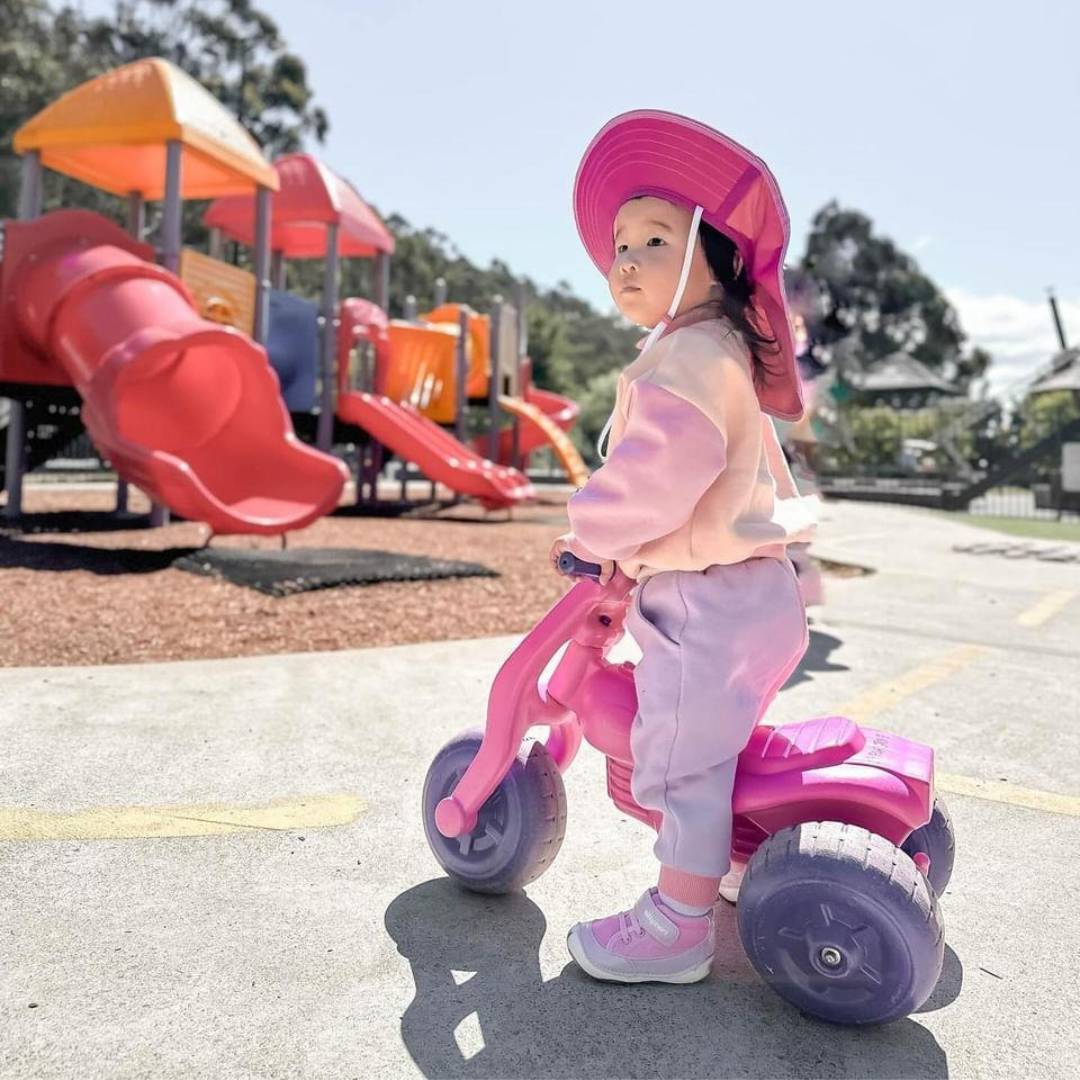 Little girl wearing Billycart kids Floss Pink Sneakers while riding a bicycle